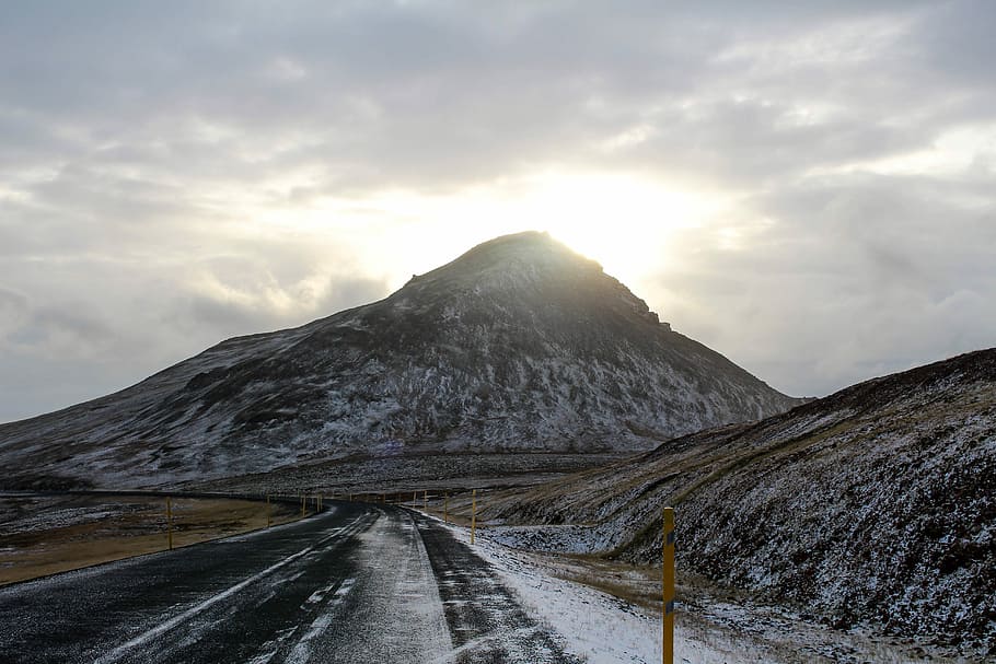 mountain near asphalt road during daytime, black concrete road between glacier mountain at daytime HD wallpaper