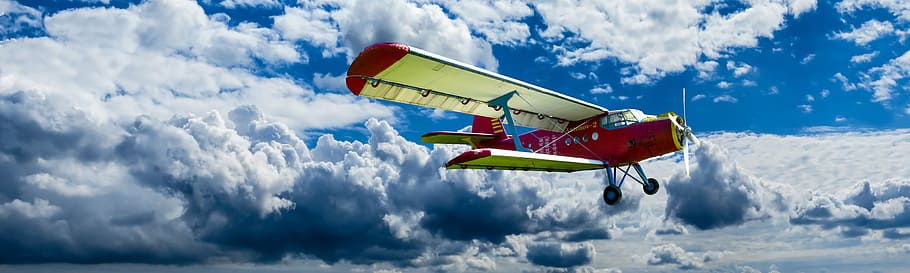 yellow and red plane flying under white clouds, aircraft, propeller
