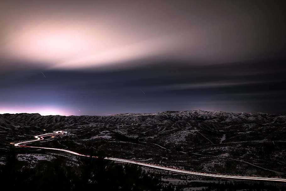 time lapse photography of cars and road, mountains under cloudy skies HD wallpaper