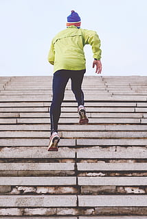person climbing concrete stairs, man wearing green jacket climbing on stairs HD wallpaper