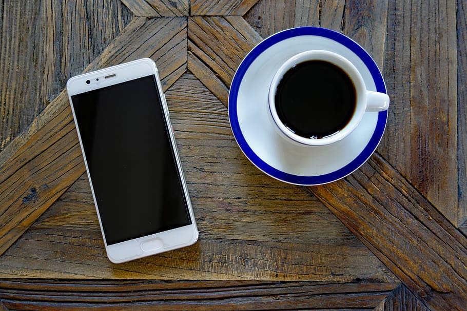 white Android smartphone near filled cup, mobile phone, huawei HD wallpaper