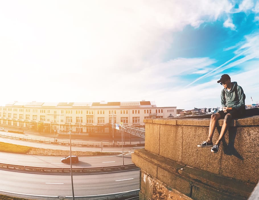 man wearing gray hooding sitting on edge of building, summer HD wallpaper