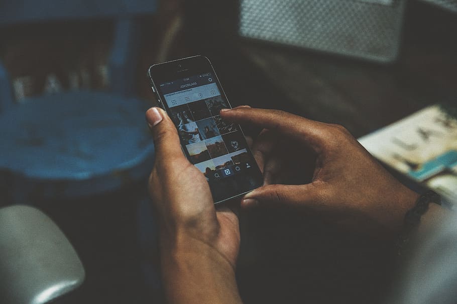 person browsing on his/her phone, person holding smartphone displaying Instagram application HD wallpaper