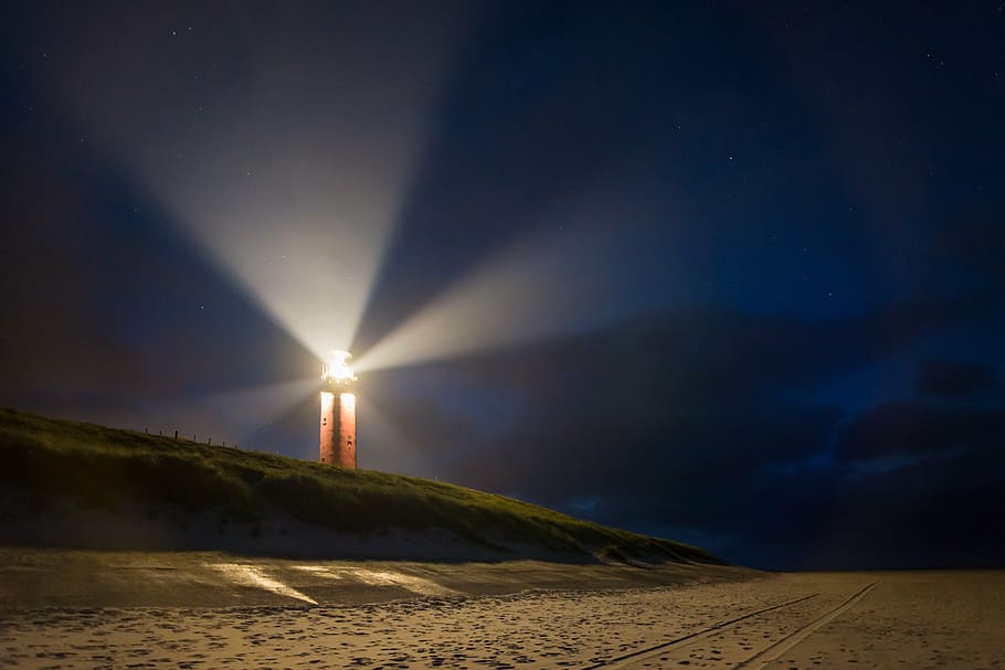 lighthouse near beach with ray of lights, night, beacon, mood HD wallpaper