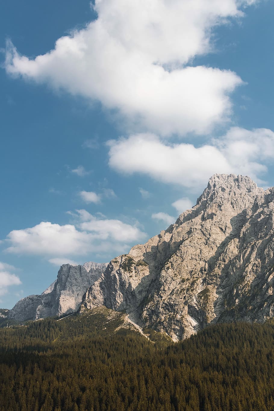 gray rock mountain under blue sky, white clouds above gray mountain HD wallpaper
