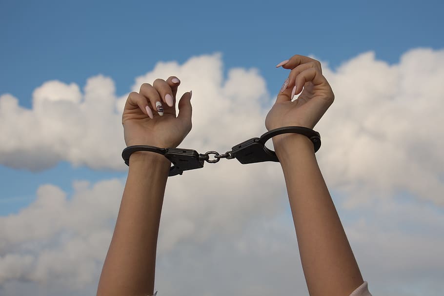 person's raised hands with handcuffs, Dependence, the dependence of