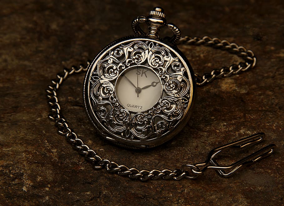 silver-colored pocket watch with link strap, jewel, chain, stone