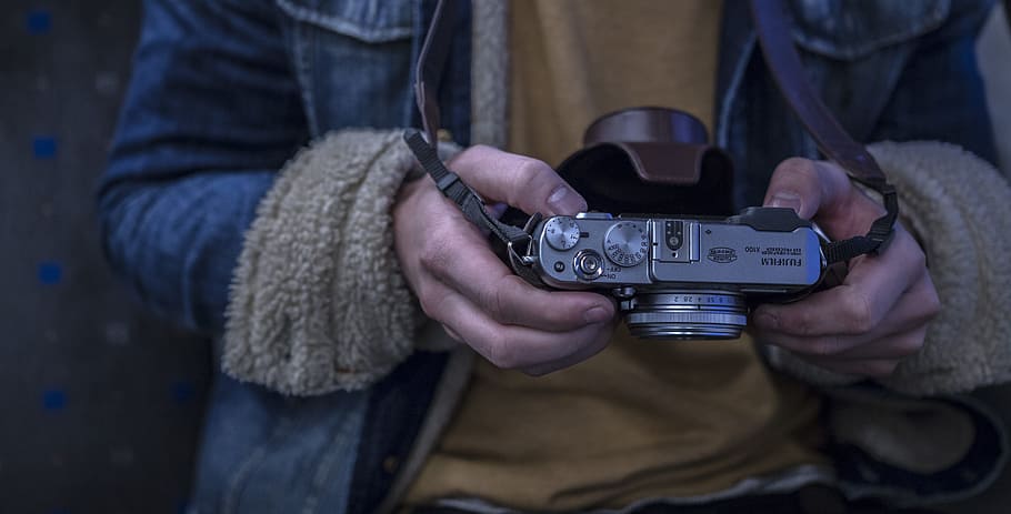 person holding camera, person in blue jacket holding gray camera, HD wallpaper