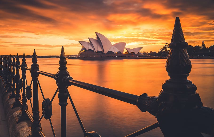 view of Sidney Opera House from across water during sunset HD wallpaper