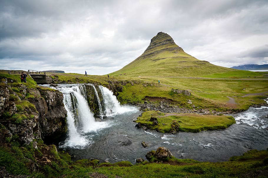 photo of waterfalls beside hill during cloudy daytime, time-lapse landscape photography of people gathered near waterfalls HD wallpaper