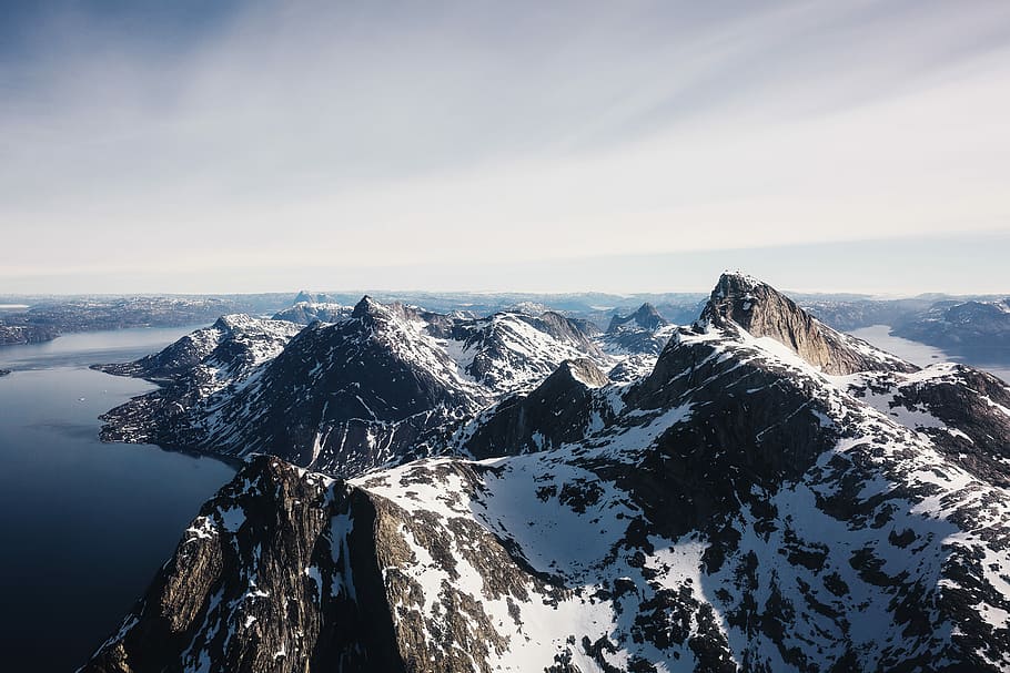 aerial photo of glacier mountain near body of water during daytime, snow mountain beside body of water aerial photography at daytime HD wallpaper