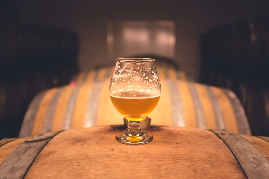 shallow focus photography of clear goblet glass on top of beer barrel HD wallpaper