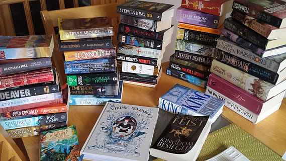 assorted-title novel books on brown wooden table, bookworm HD wallpaper