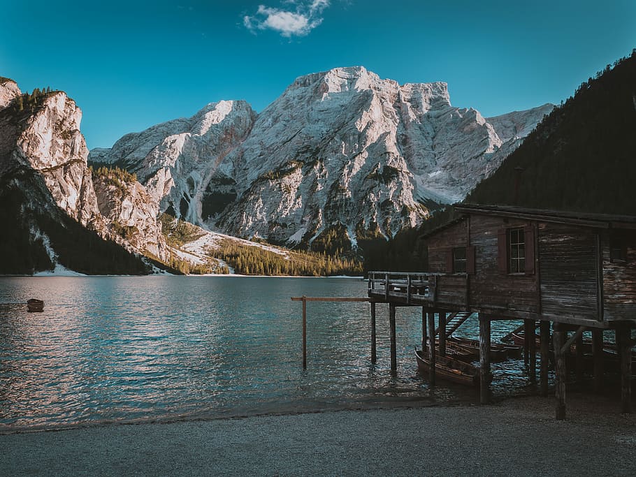photo of wooden house near body of water and mountain, gray shed and white mountain HD wallpaper