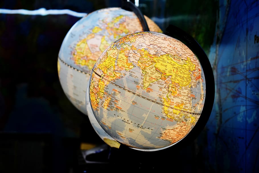 shallow focus photography of two desk globe, two desk globes inside blue room HD wallpaper