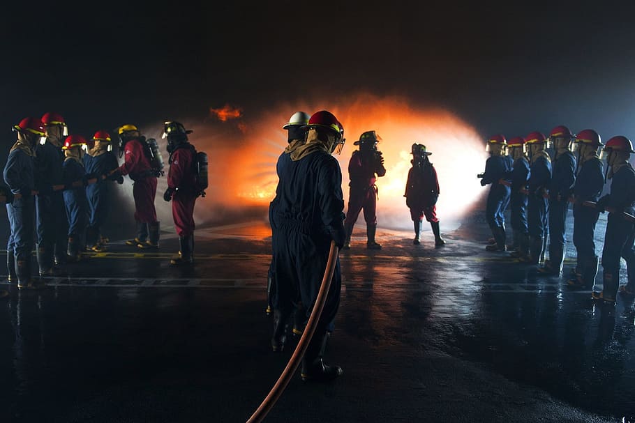 fireman holding water hose infront of fire, firefighters, training