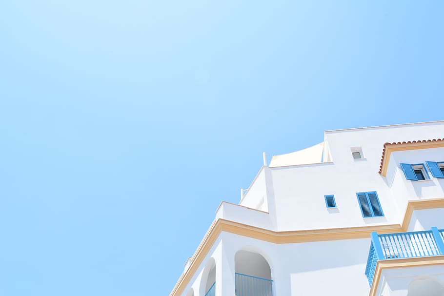 painted painted house under blue sky, white and blue concrete building under calm sky