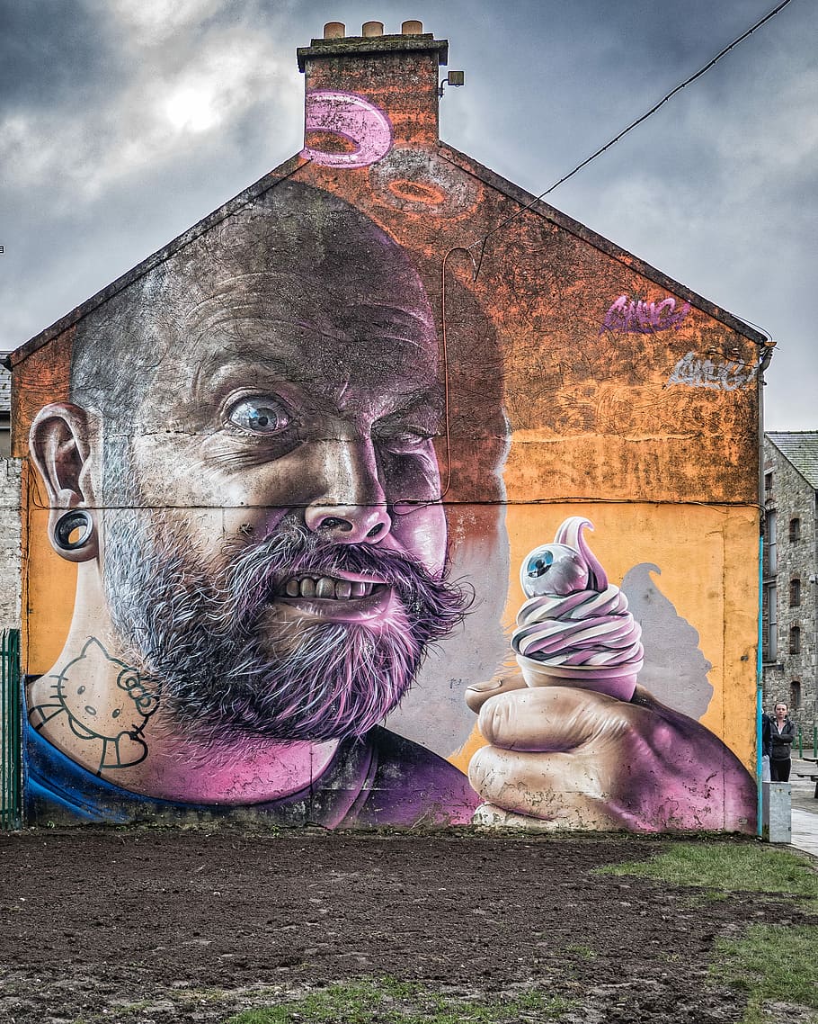 man-printed concrete house under cumulus clouds, man with ice cream wall graffiti