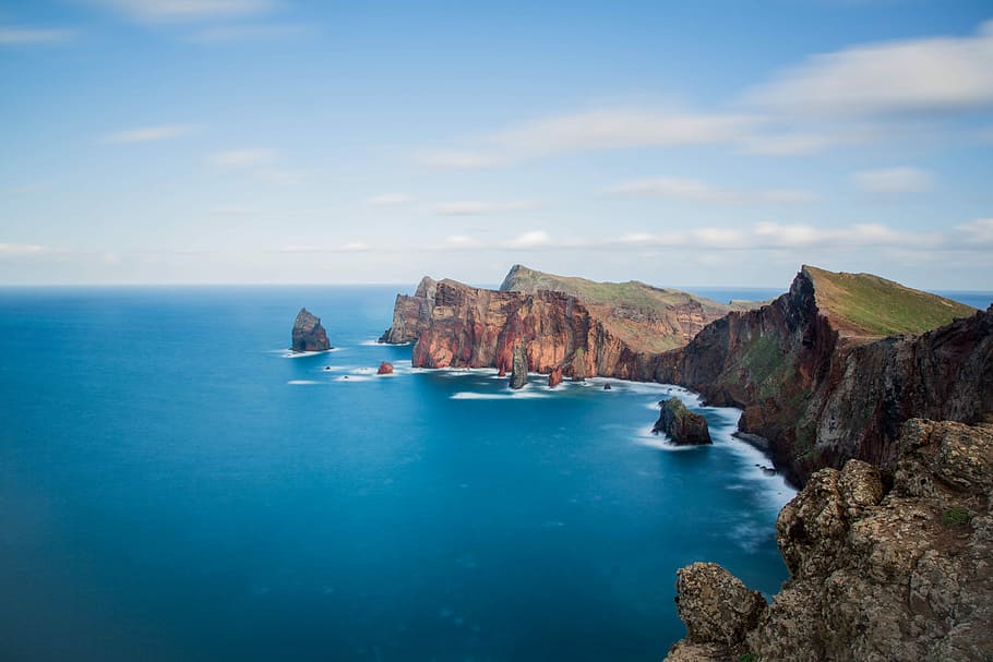 landscape photography of blue body of water with island, aerial photography of cliff surrounded by body of water HD wallpaper