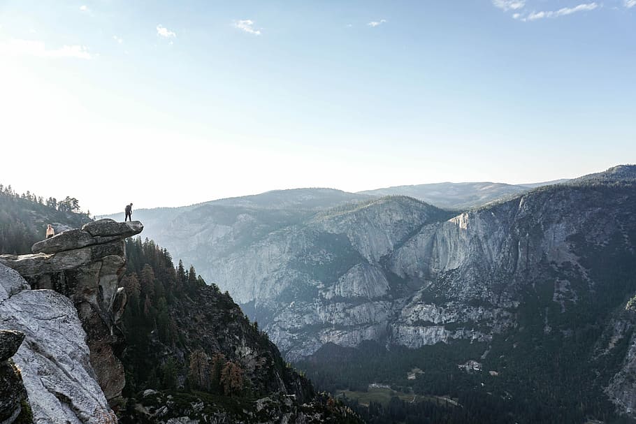 person standing on edge of mountain, person standing on edge of rock HD wallpaper