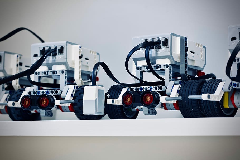 two white and black electronic device with wheels, two gray robots illustration HD wallpaper
