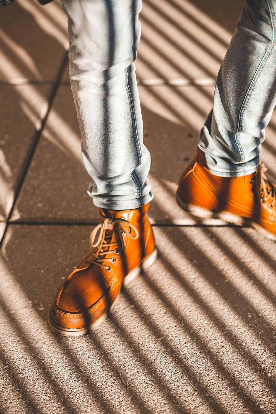 person standing on gray concrete pavement wearing pair of brown elather boots HD wallpaper