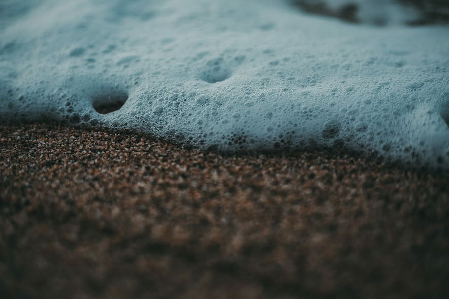 white bubbles on brown soil, photo of brown sand, foam, water