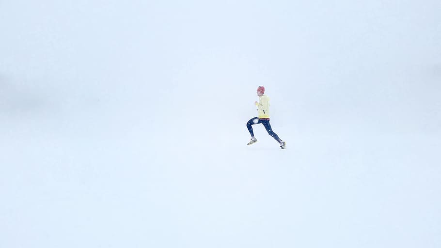 person wearing yellow jacket and black pants, person in yellow sweatshirt and black pants running in white room