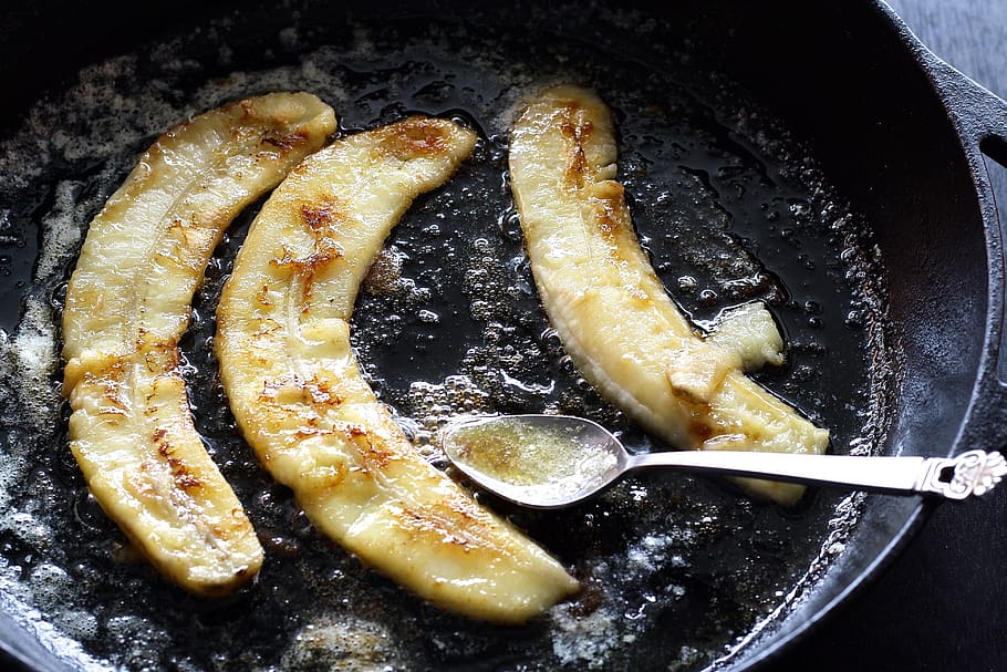 three fried bananas on frying pad with spoon, caramelized, food