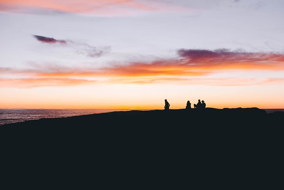 group of people on top of mounted near body of water during sunset, silhouette photo of people on seashore HD wallpaper