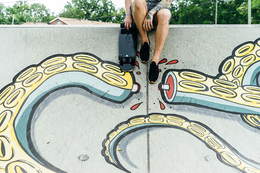 man sitting beside black skateboard, person holding black skateboard, HD wallpaper