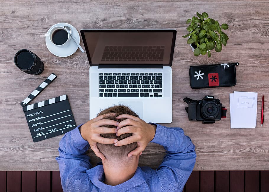 closeup photo of man facing gray laptop on table, filmmaker, youtuber
