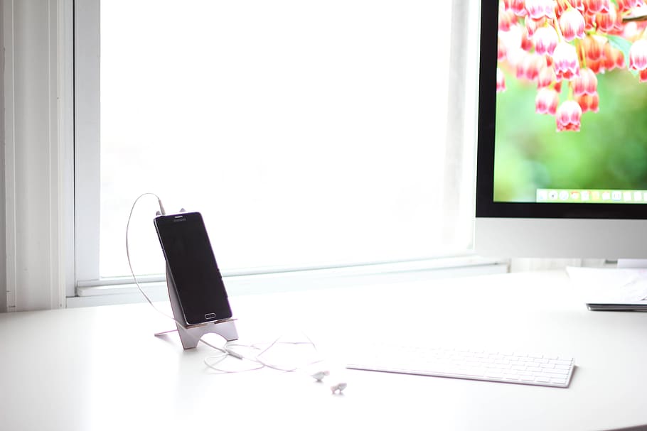 phone charging on table, computer, keyboard, apple, iphone, electronics