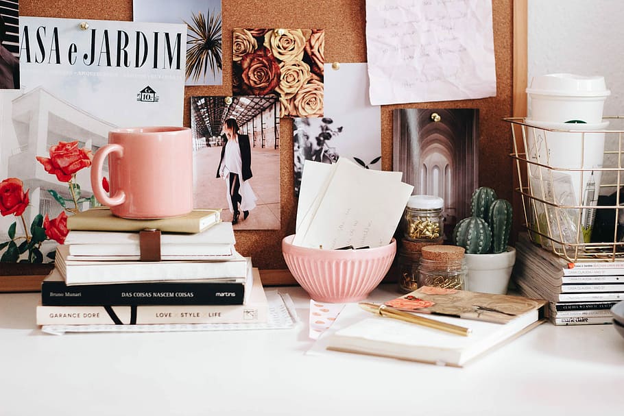 pink mug on stacked books, book and mug on table, workspace, desk