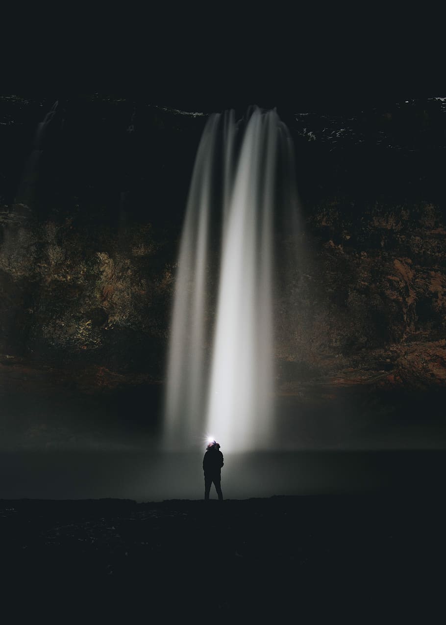 man standing in front of waterfalls during nighttime, person standing near waterfalls, HD wallpaper