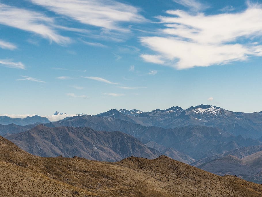 brown rocky mountain under blue sky during daytime, high-angle photography of mountain ranges under white clouded blue sky during daytime HD wallpaper