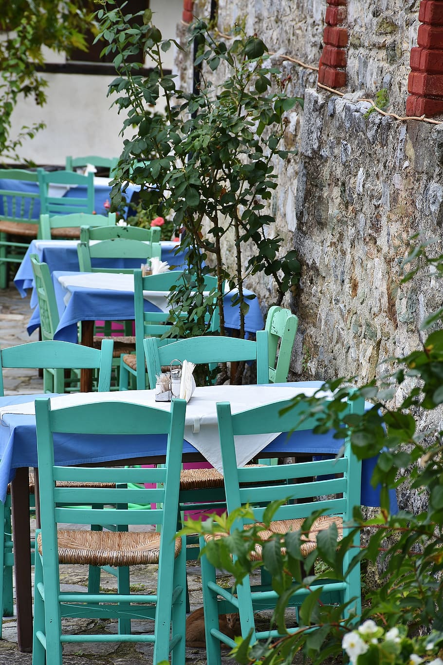 teal and blue wooden tables and chairs beside concrete wall HD wallpaper