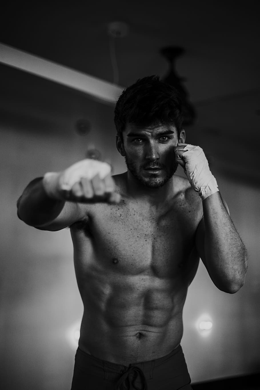 grayscale photo of a man boxing in a room, boxer, workout, portrait