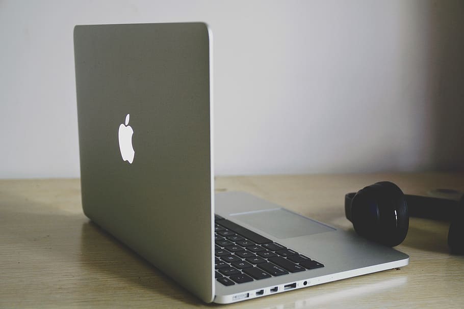 silver MacBook near wireless headphones, MacBook Pro near headphones HD wallpaper
