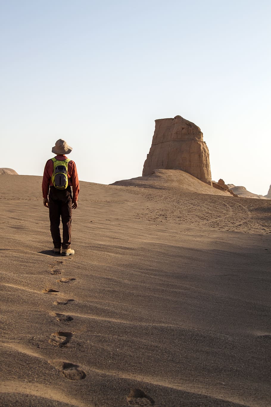 man wearing hat walking on desert, man walking on desert while fronting rock formation, HD wallpaper