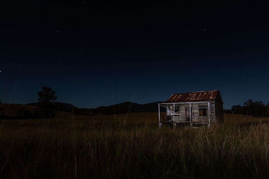gray and brown wooden house surrounded by grass near mountain, brown and black wooden house surrounded by green grass at night HD wallpaper