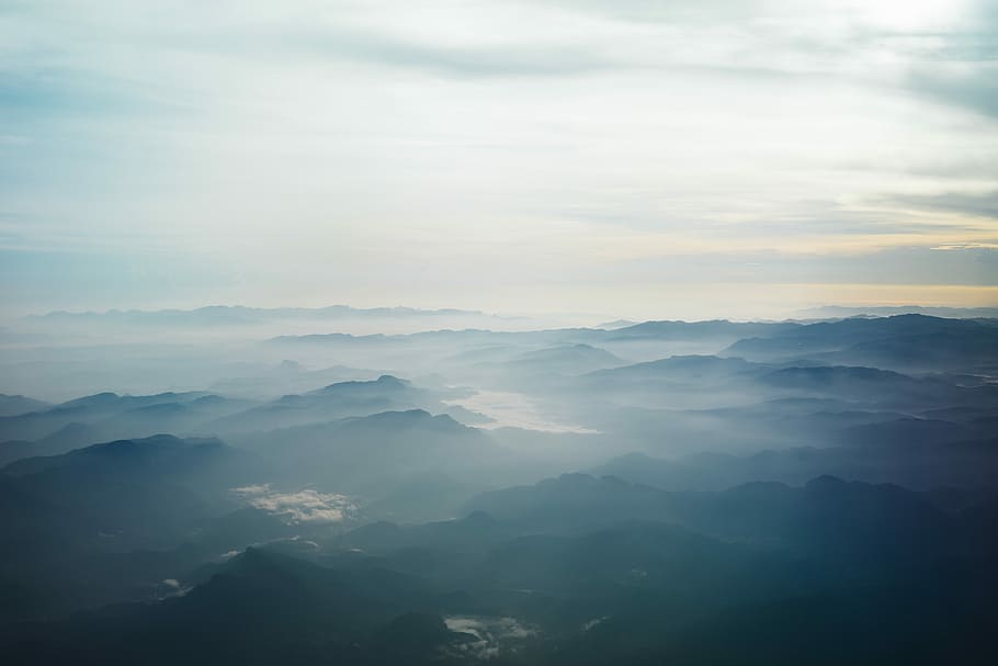 aerial photography of blue mountains surrounded by fogs under white sky at daytime, aerial photo of mountain covered with fogs during daytime HD wallpaper