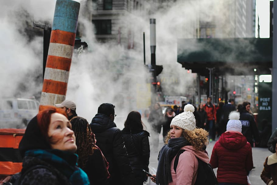 people standing near teal concrete building, people walking on road covered with smoke HD wallpaper