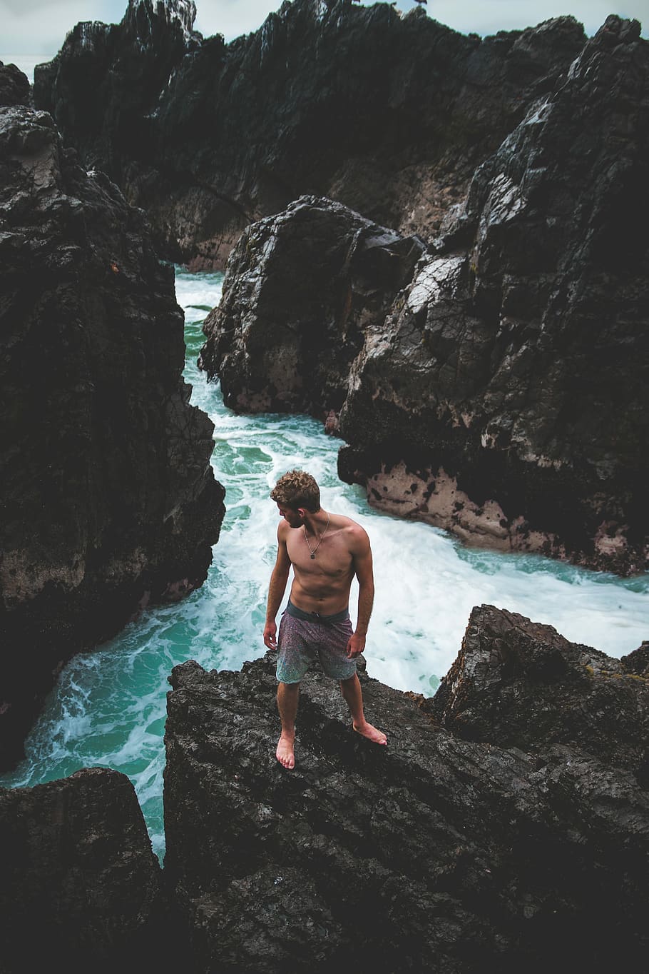 man standing on gray stone near cliff during daytime, man standing on cliff near seashore HD wallpaper