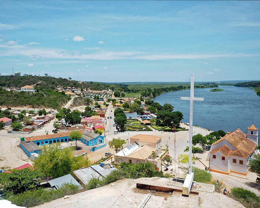 Muxima, white cross over houses and body of water during daytime HD wallpaper