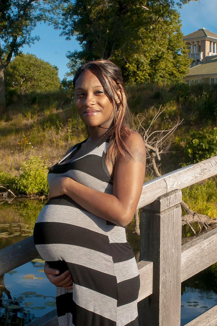 standing pregnant woman smiling beside gray wooden bridge during daytime, HD wallpaper