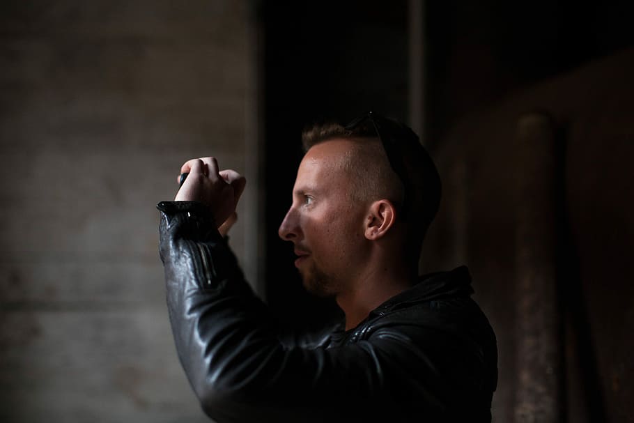 man wearing black leather jacket standing in dark room, men, one Person HD wallpaper