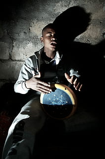 man playing percussion instrument near wall, man playing drum while sitting beside wall HD wallpaper