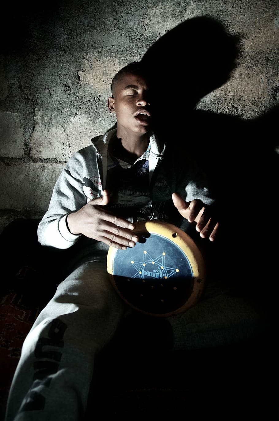 man playing percussion instrument near wall, man playing drum while sitting beside wall HD wallpaper