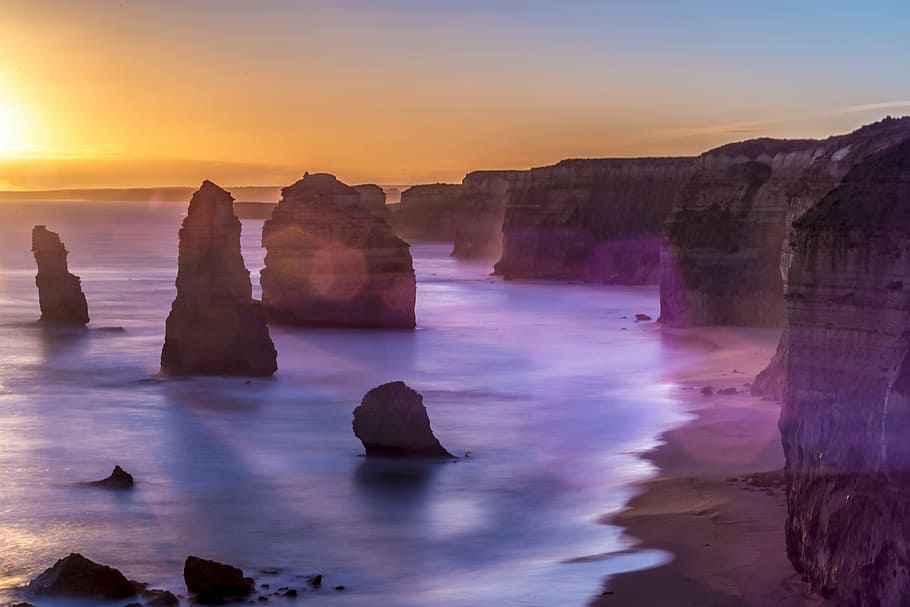 landscape photography of rock formation near the body of water HD wallpaper